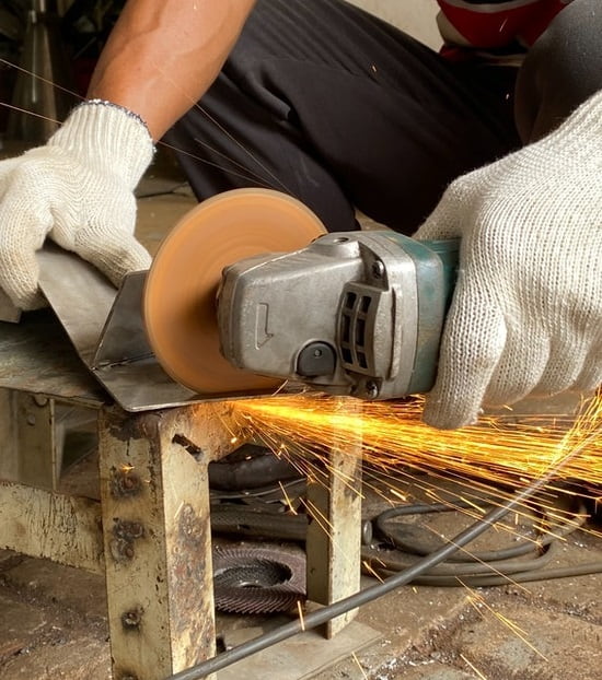 cortando pieza de metal con herramienta eléctrica