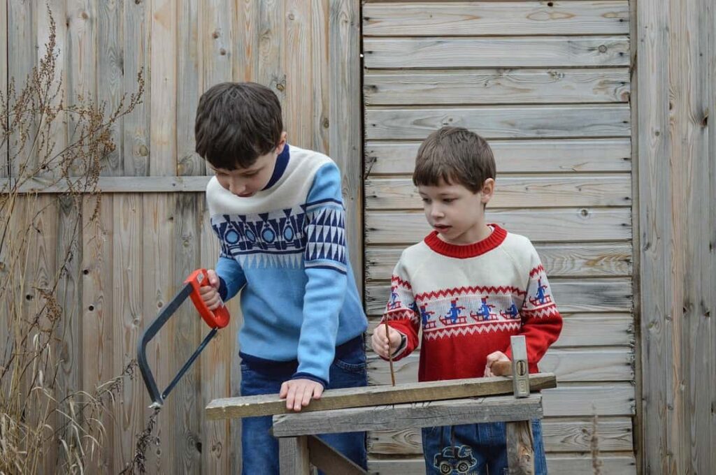 niños usando herramientas para cortar madera
