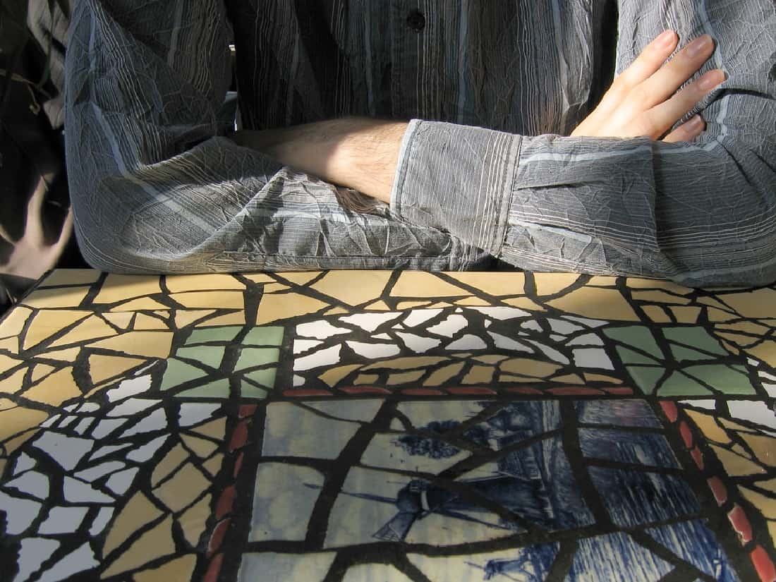brazos apoyados en mesa con azulejos